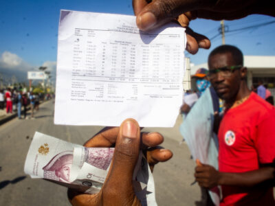 Un ouvrier de SONAPI lors d’une marche en mai 2023 sur la Route de l’aéroport à Delmas, protestant contre les pratiques illégales des employeurs de la sous-traitance, montre une fiche de paie mentionnant la part de son salaire prélevée pour l’ONA et l’OFATMA.