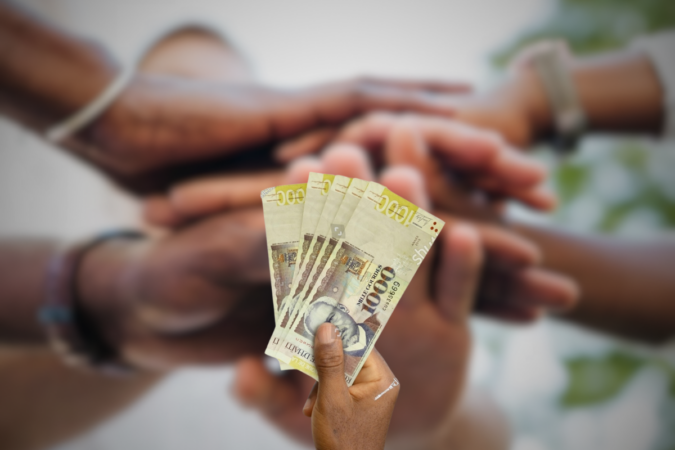 Une main qui donne de l'argent haitien