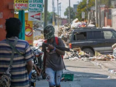 Armed members of the G9 gang stand guard at their roadblock in Port-au-Prince, Haiti, on Monday, March 11, 2024. ODELYN JOSEPH / AP