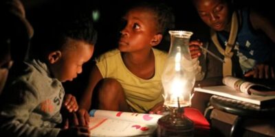 Children use a paraffin lamp to study during a blackout in Soweto © Siphiwe Sibeko/Reuters