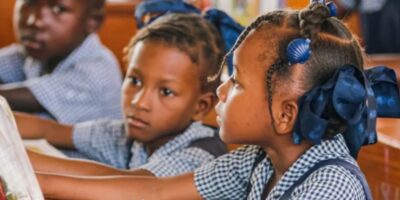 Des élèves d'une école primaire d'Haïti plongés dans la joie de lire ensemble dans leur classe. Peleg Charles