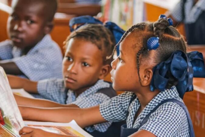 Des élèves d'une école primaire d'Haïti plongés dans la joie de lire ensemble dans leur classe. Peleg Charles
