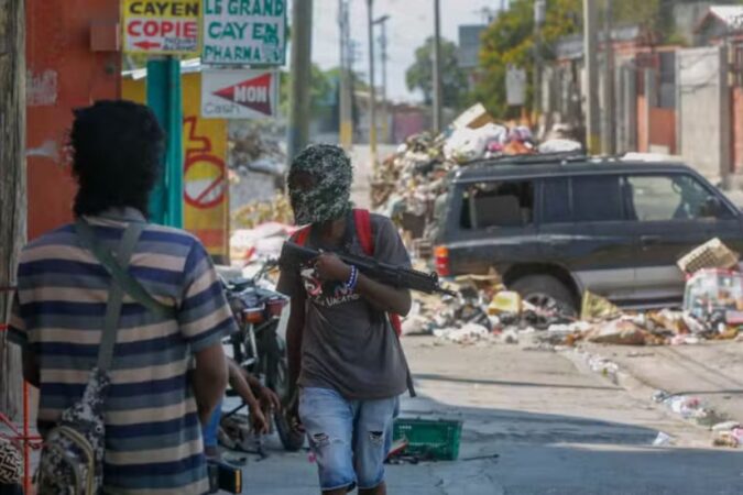 Armed members of the G9 gang stand guard at their roadblock in Port-au-Prince, Haiti, on Monday, March 11, 2024. ODELYN JOSEPH / AP