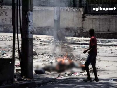 Un adolescent curieux scrute des yeux un corps calciné dans les rues de Port-au-Prince le 4 mars 2024, dans la Rue Oswald Durand, à quelques mètres du Palais national.