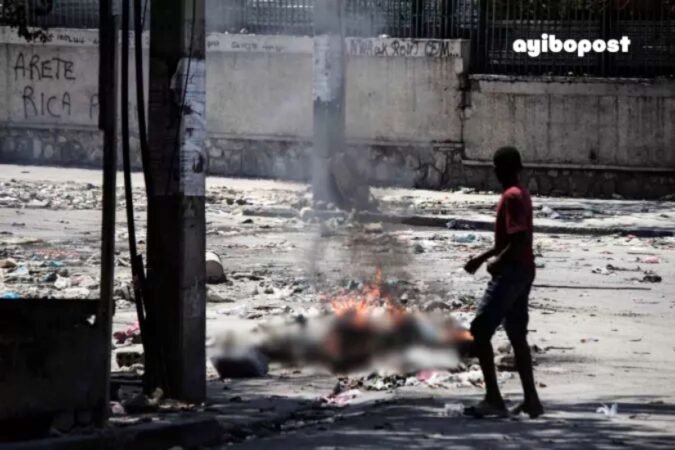 Un adolescent curieux scrute des yeux un corps calciné dans les rues de Port-au-Prince le 4 mars 2024, dans la Rue Oswald Durand, à quelques mètres du Palais national.