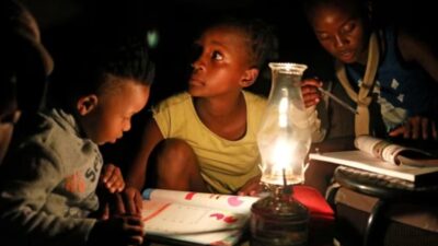 Children use a paraffin lamp to study during a blackout in Soweto © Siphiwe Sibeko/Reuters