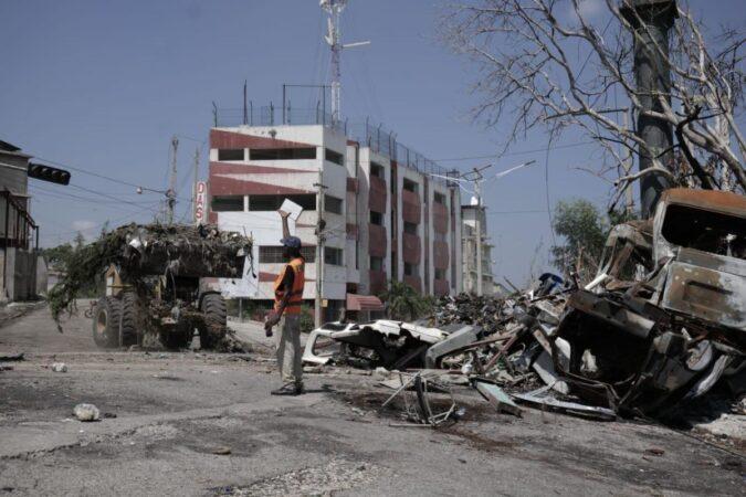 Un chargeur ramasse des tas d’ordures et de vieilles carcasses bloquant la route à Delmas 18, le XY août 2025. Photo : (Jean Feguens Regala / AyiboPost)