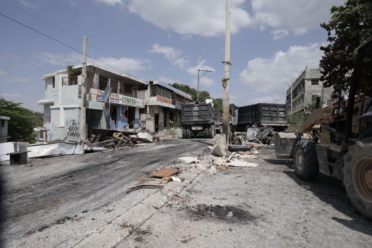 Deux camions-bennes et un chargeur déblayant la route à Delmas 7, le XY août 2025. Photo : Jean Feguens Regala / AyiboPost